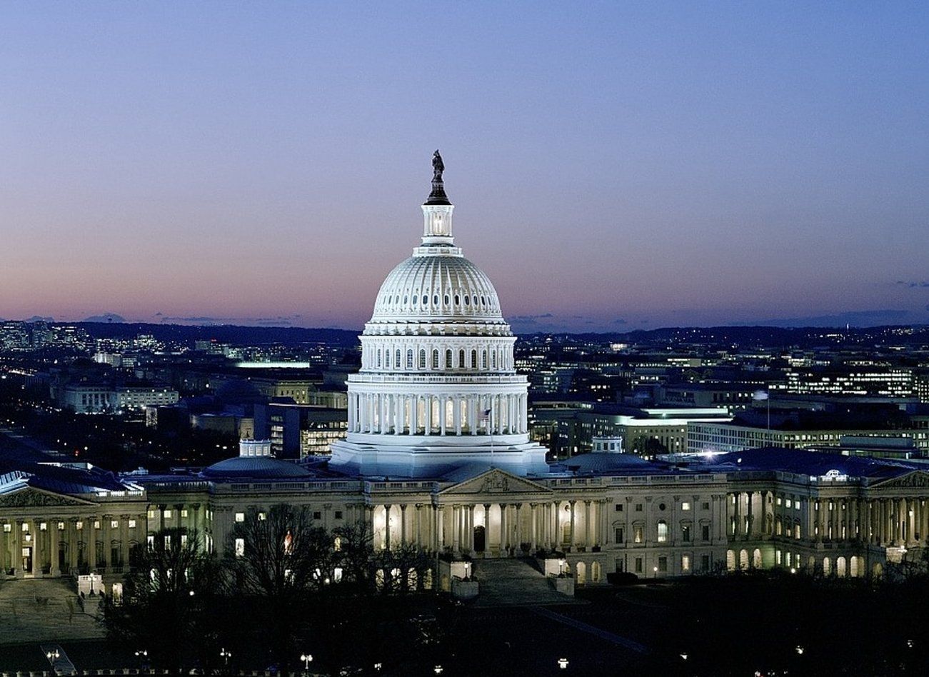 The dome of the capitol building is lit up at night