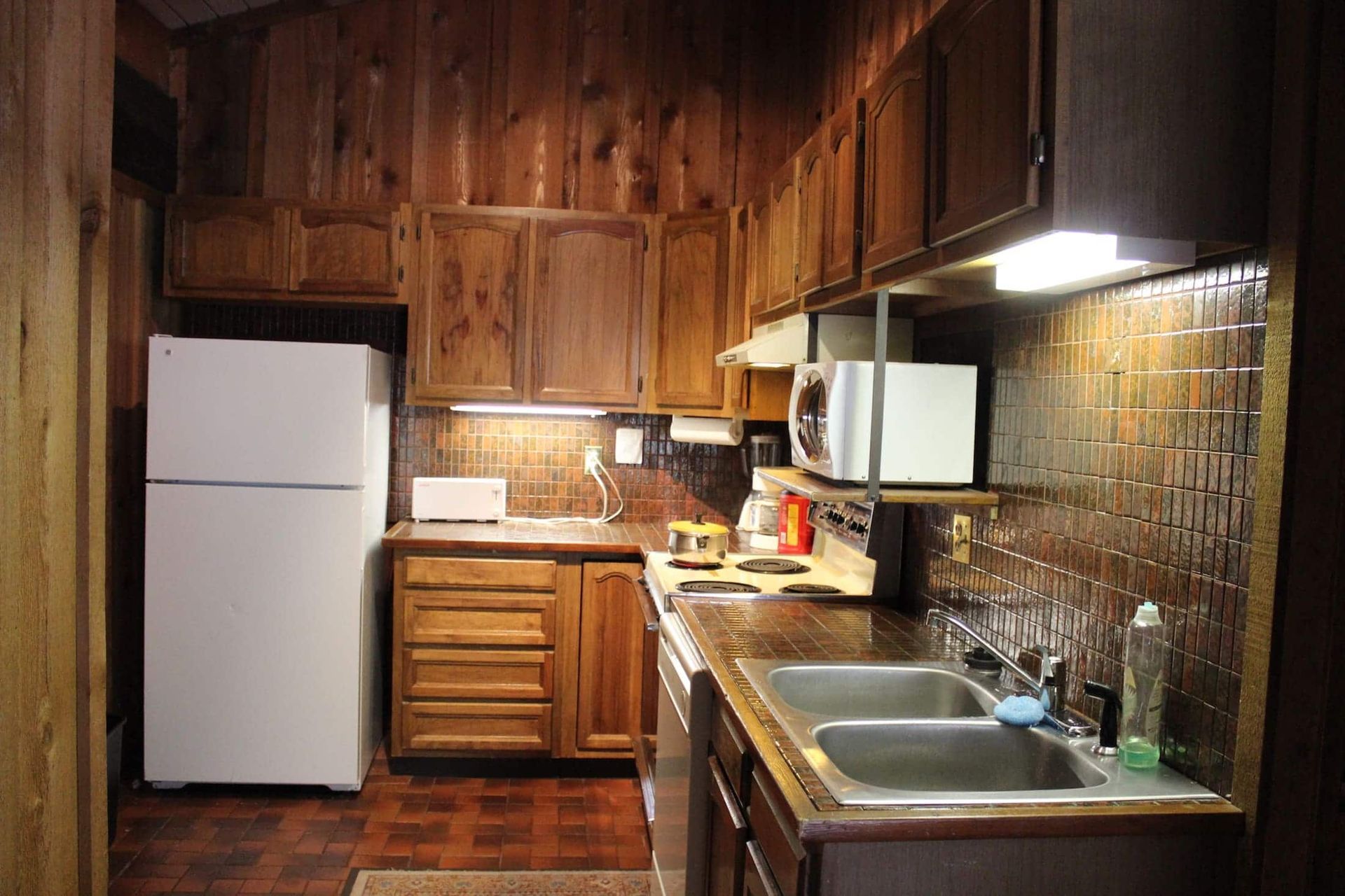 A kitchen with wooden cabinets and a white refrigerator