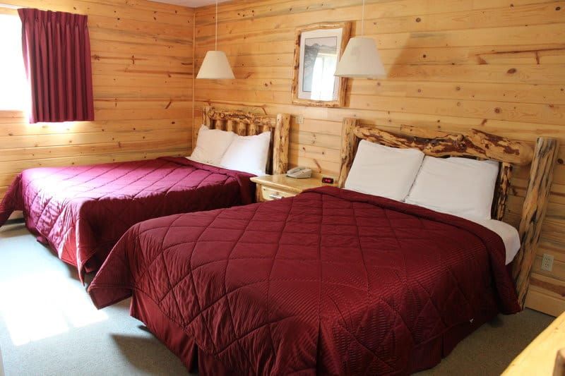 A hotel room with two beds and a mirror