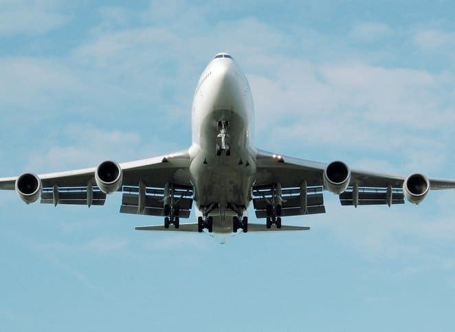 A large passenger jet is flying through a clear blue sky.