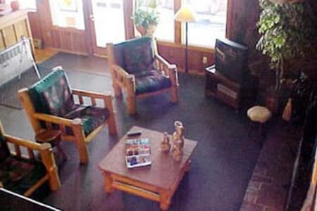 A living room with a table , chairs , and a television.