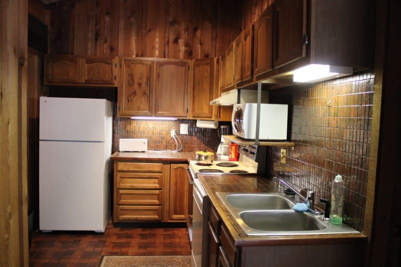 A kitchen with wooden cabinets and a white refrigerator