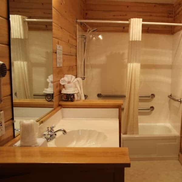 A bathroom with a sink a tub and a mirror