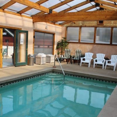 A large indoor swimming pool with chairs around it