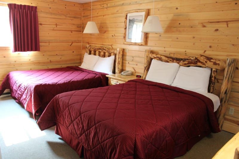 A hotel room with two beds and a mirror