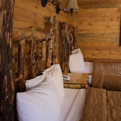 There are two beds in the room with a wooden headboard.