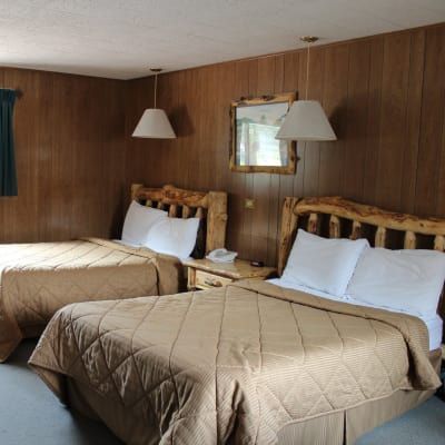 A hotel room with two beds and a mirror