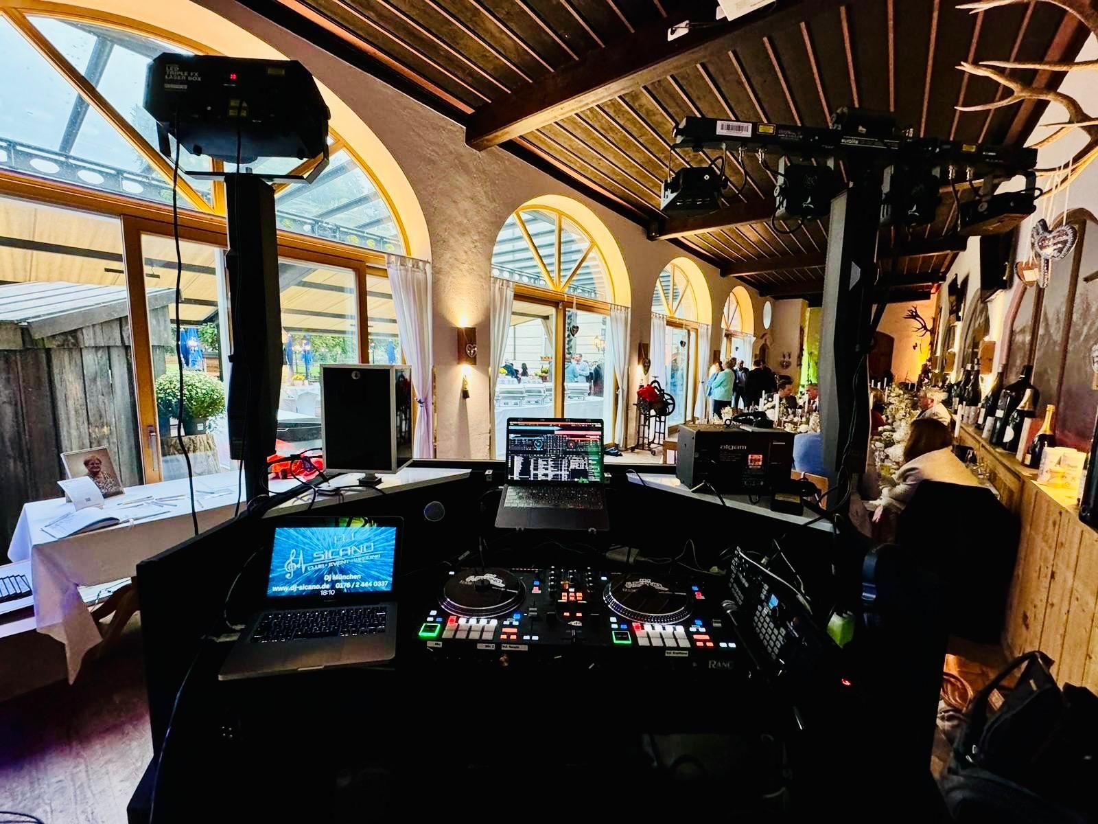 Ein DJ spielt mit einem Projektor Musik in einem Restaurant.
