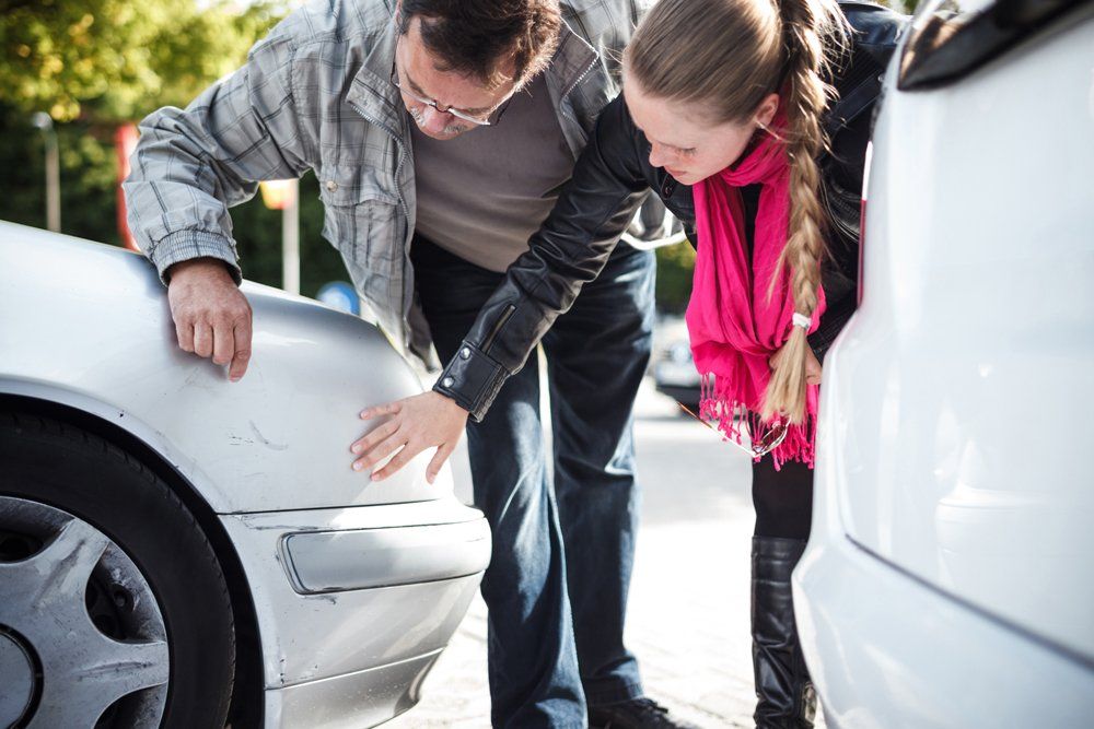 Man And Woman Examining Car After Accident — Port Washington, NY — Professional Insurance Consultants Inc. Man And Woman Examining Car After Accident — Port Washington, NY — Professional Insurance Consultants Inc.