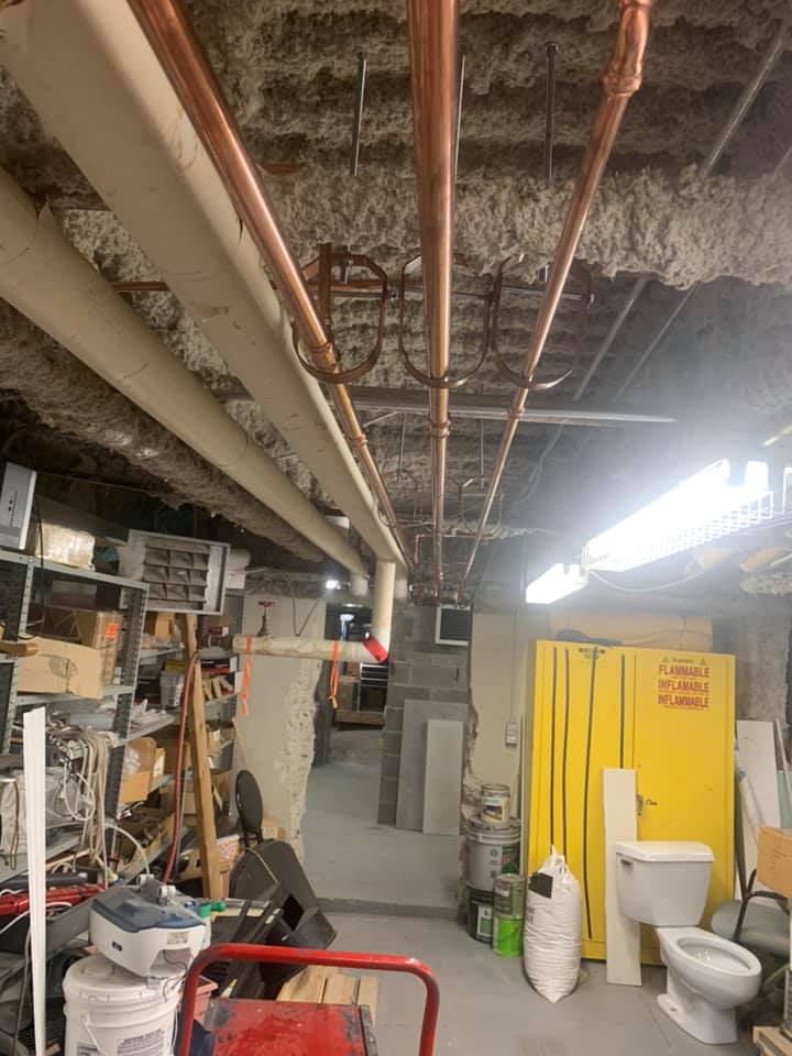 Il y a beaucoup de tuyaux suspendus au plafond dans cette pièce.