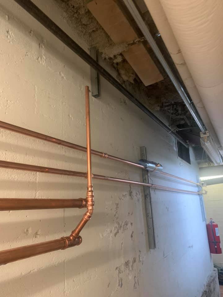 Une rangée de tuyaux en cuivre suspendus au plafond d'un bâtiment.