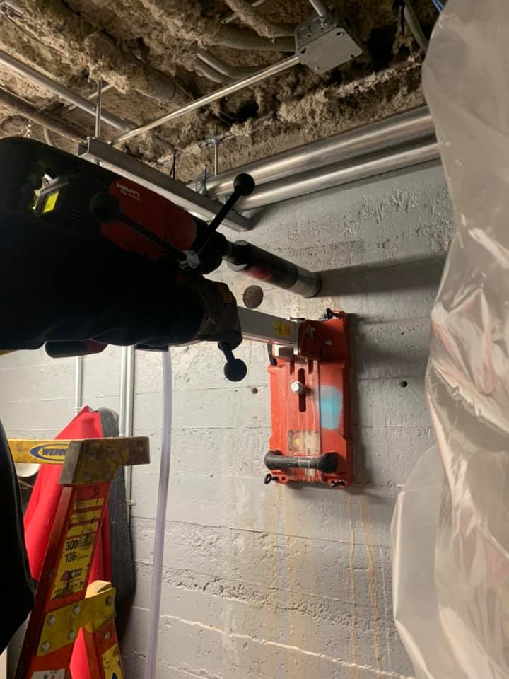 Une personne utilise une machine pour percer un trou dans un mur.