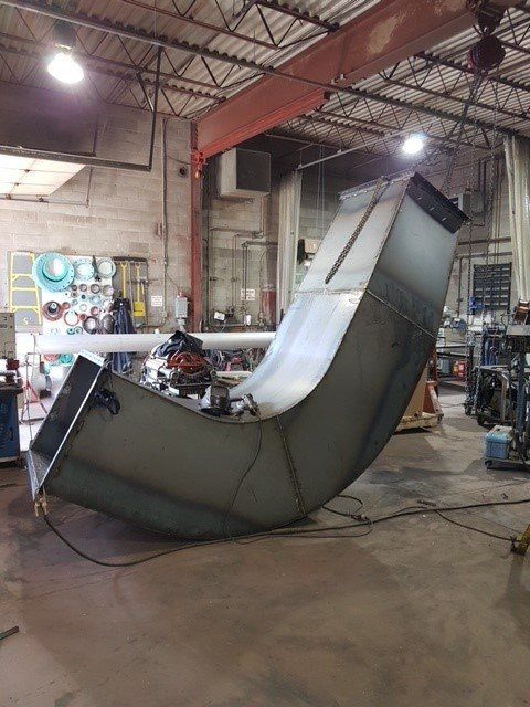 Un gros morceau de métal repose sur le sol d'une usine.