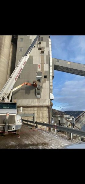 Un camion avec une grue attachée travaille sur un bâtiment.