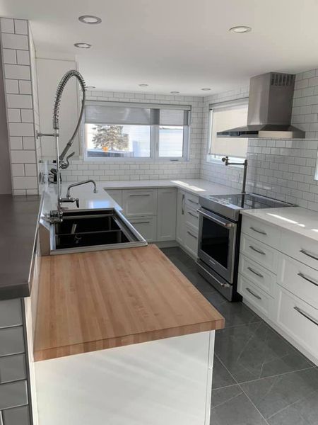 Une cuisine avec des armoires blanches et un comptoir en bois.