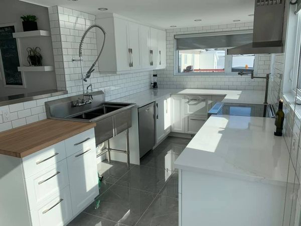 Une cuisine avec des armoires blanches et des appareils électroménagers en acier inoxydable