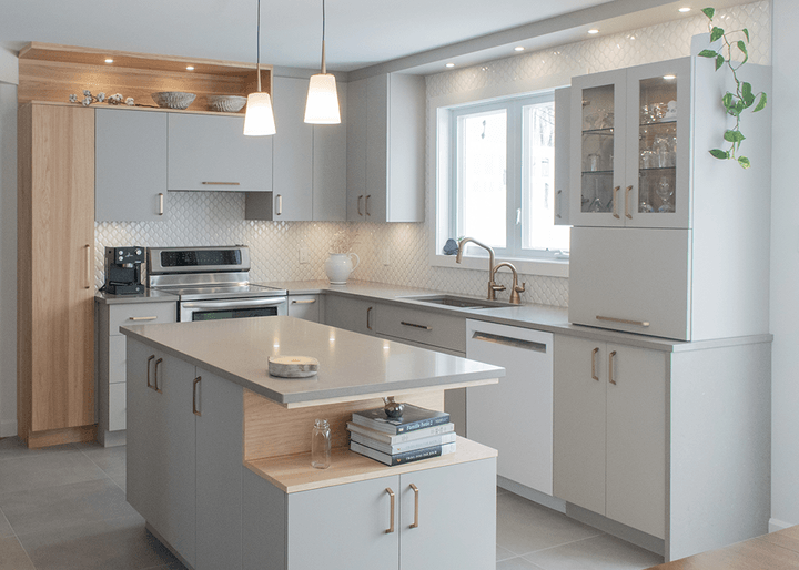 Une cuisine avec des armoires blanches et un grand îlot au milieu.