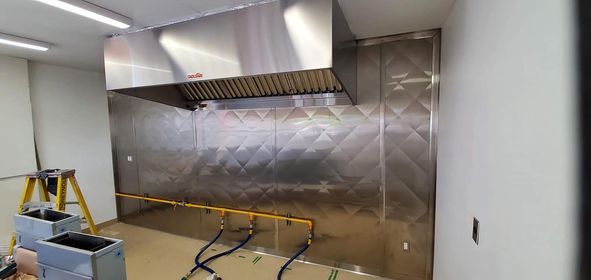 Une cuisine avec une hotte en inox et une échelle.