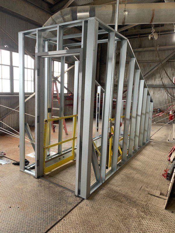 Une grande structure métallique est en cours de construction dans un bâtiment.