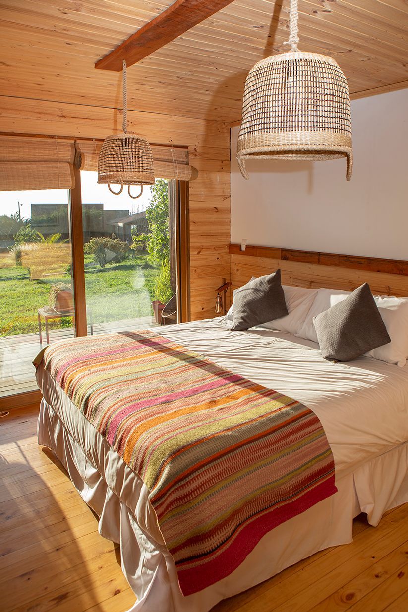 Dormitorio bañado de luz dorada con cama, mesita de noche y alfombra.