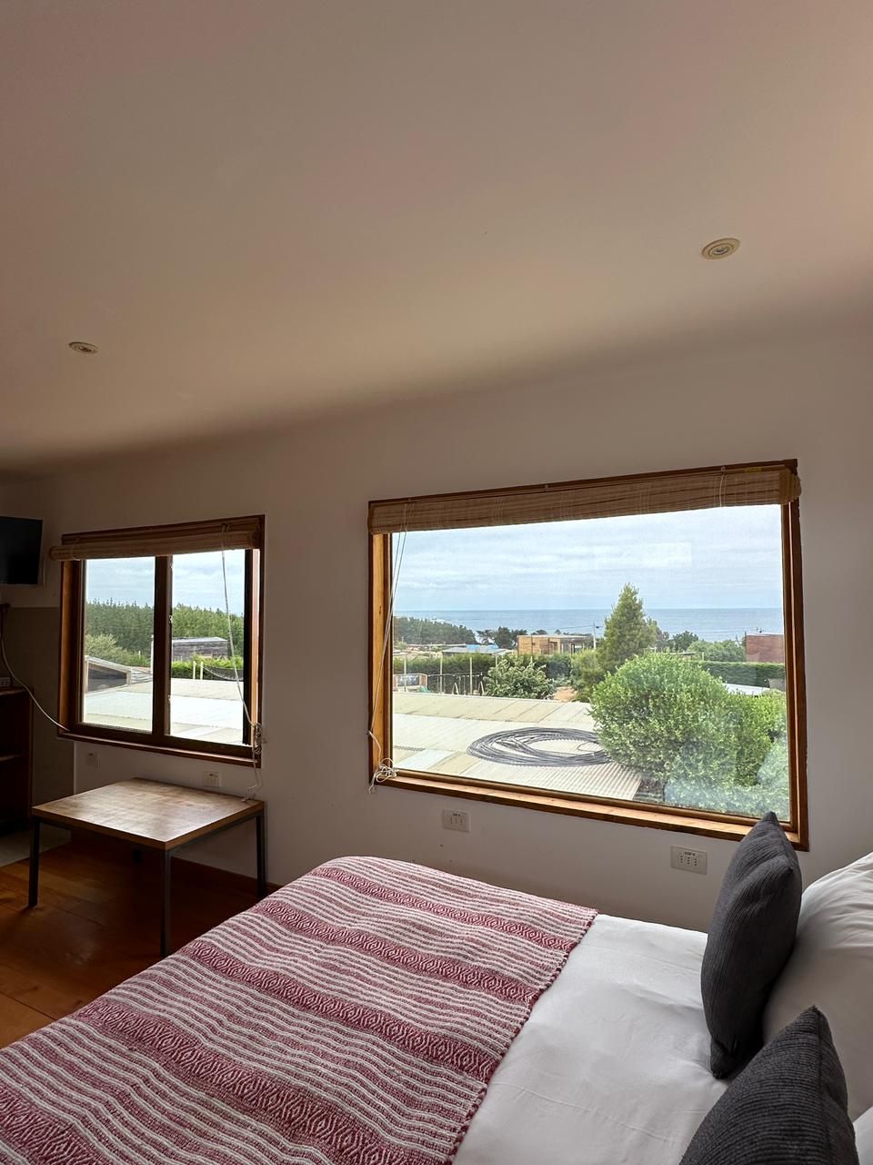 Dormitorio con una cama y dos ventanas con vista al exterior.