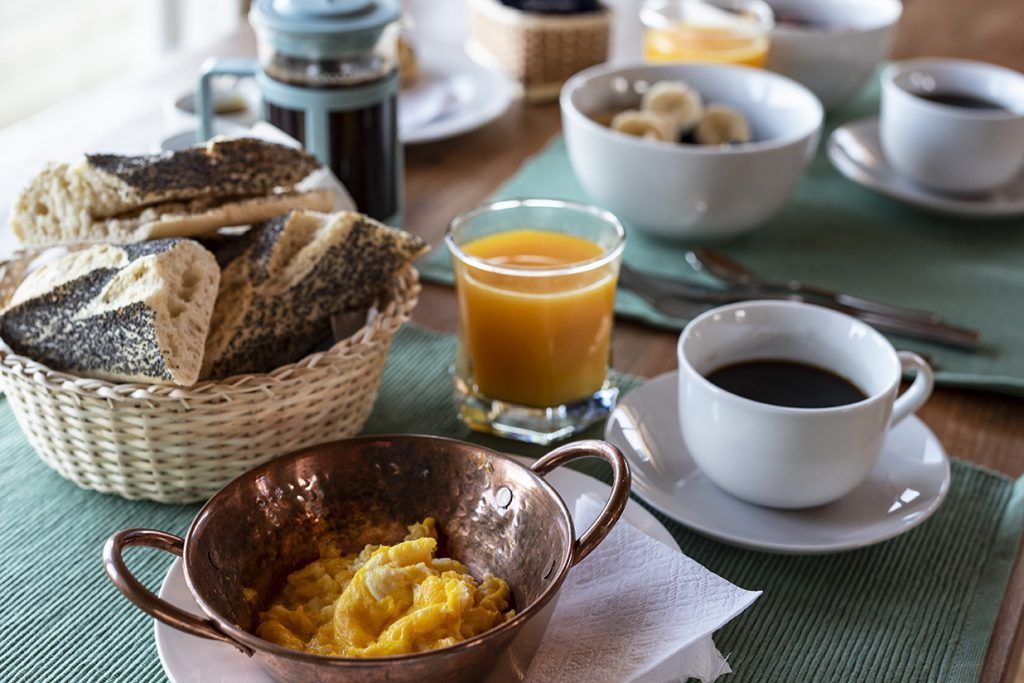 Desayuno: huevos revueltos, pan, café, zumo y fruta.