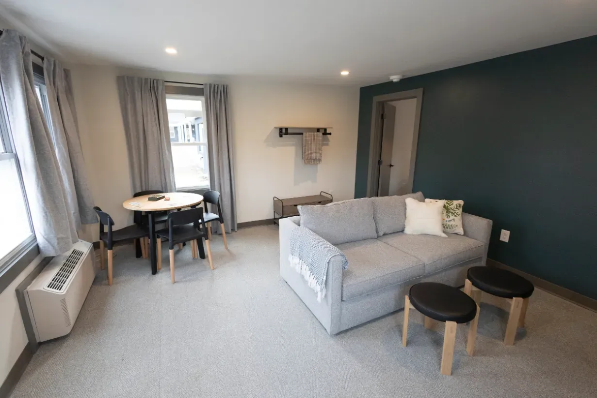 A living room with a couch , table and chairs.