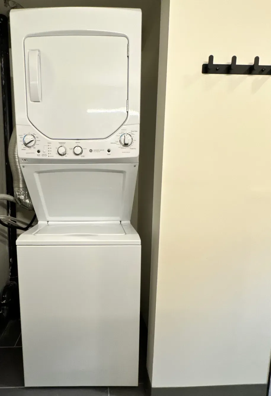 A stacked washer and dryer are sitting next to each other in a room.