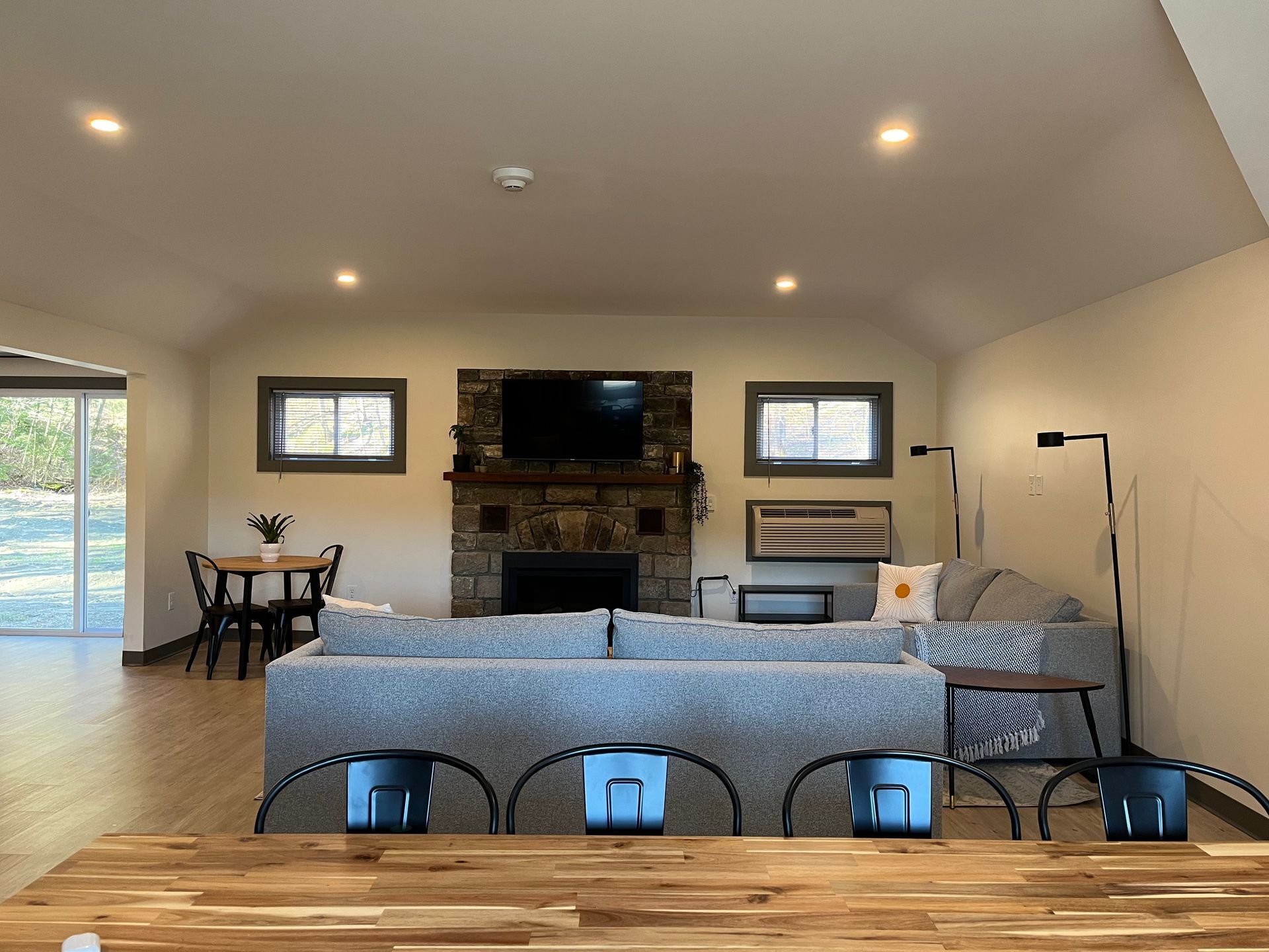 A living room with a couch , table , chairs and a fireplace.