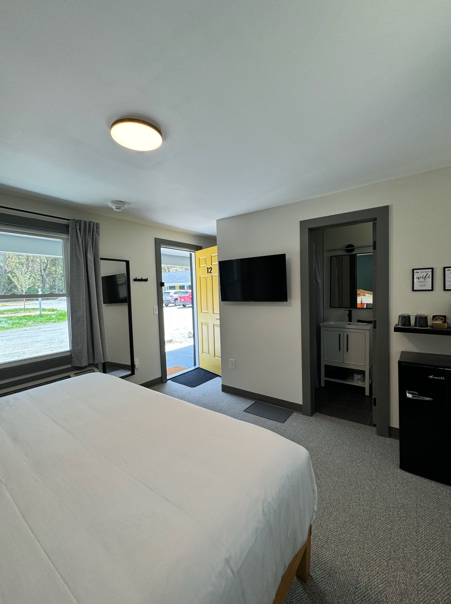 A hotel room with a king size bed and a flat screen tv.