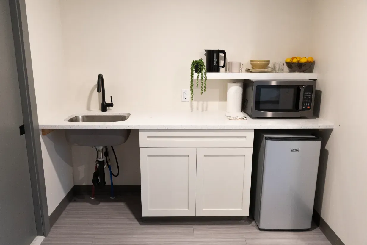 A small kitchen with a sink , microwave , and refrigerator.