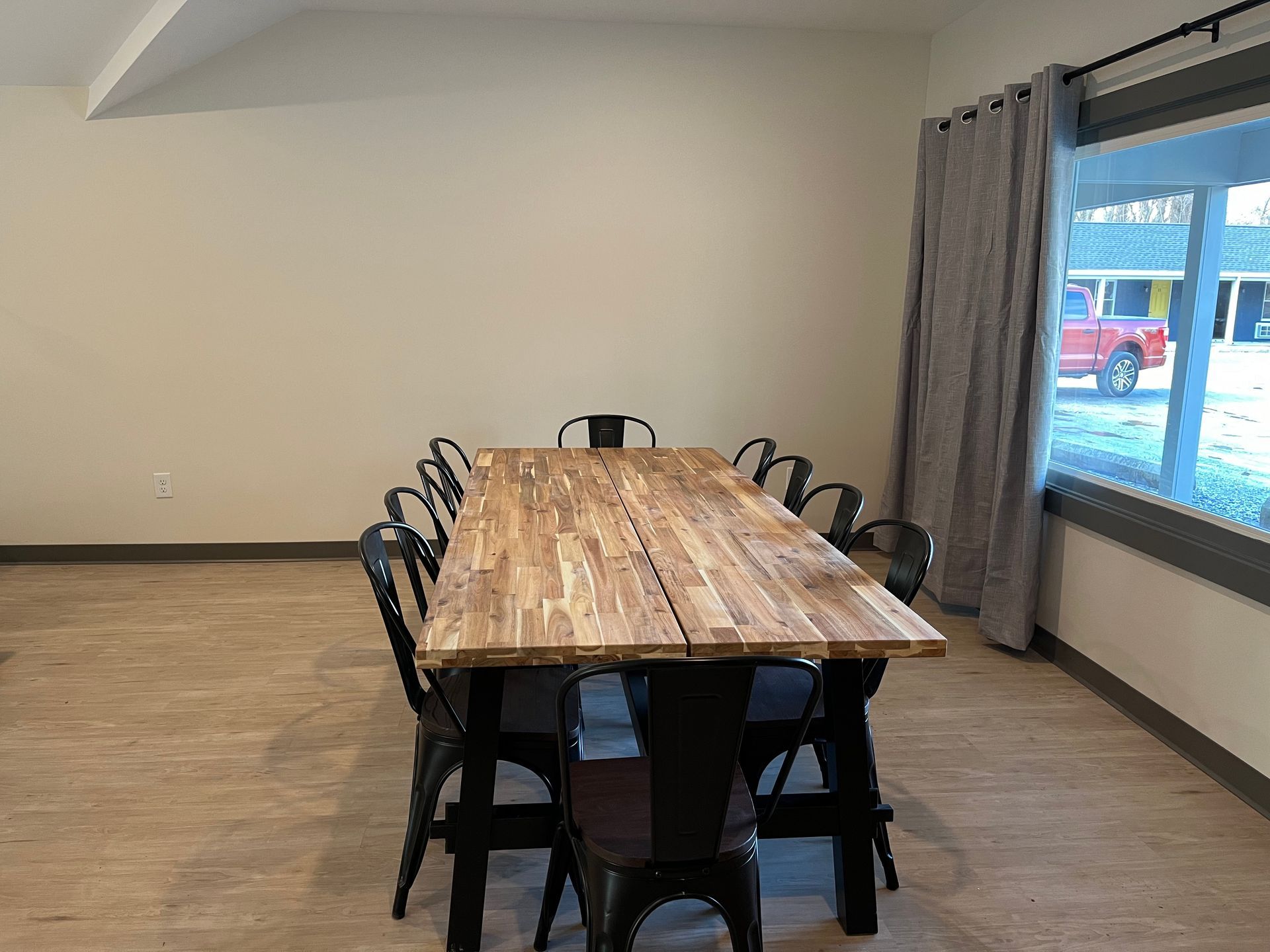 A long wooden table and chairs in a room with a window.