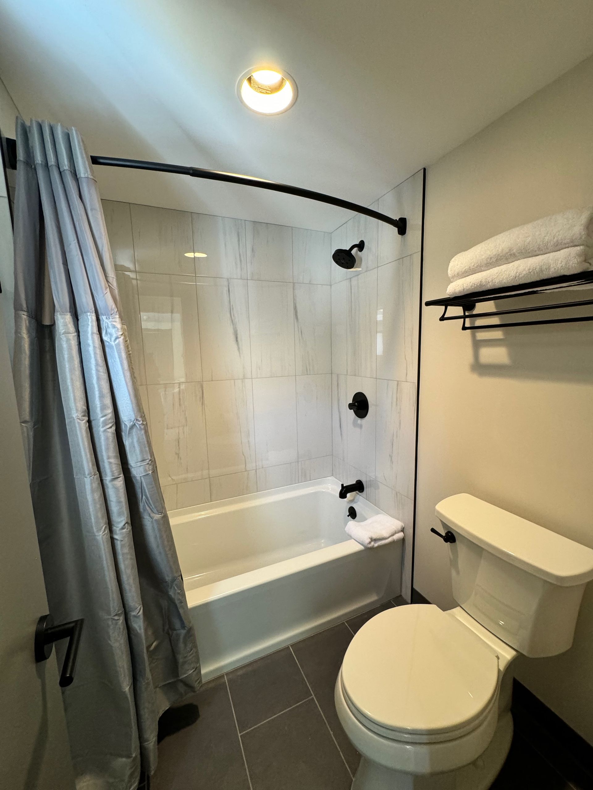 A bathroom with a toilet , bathtub and shower.