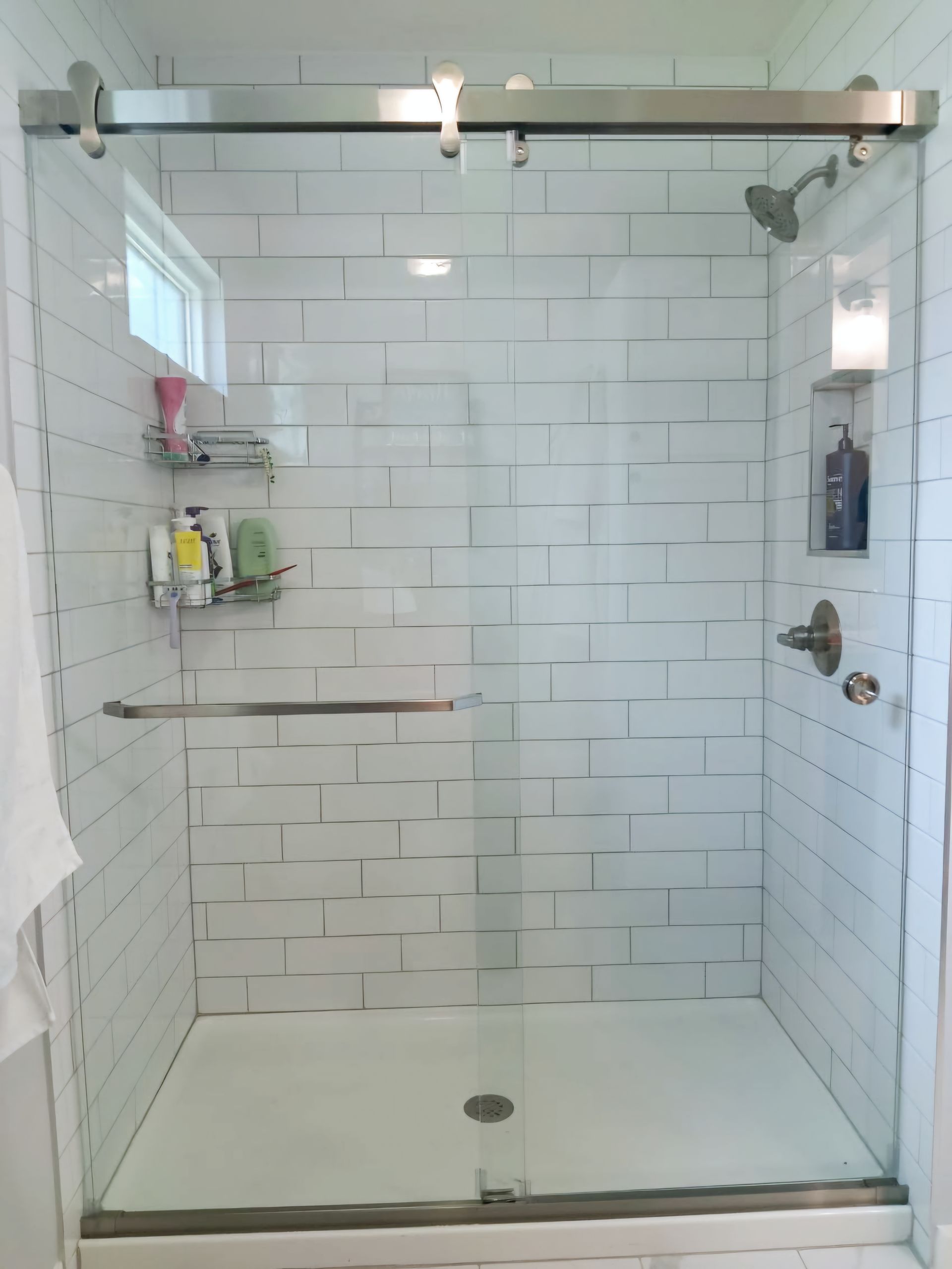 A bathroom with a toilet , sink , shower and window.