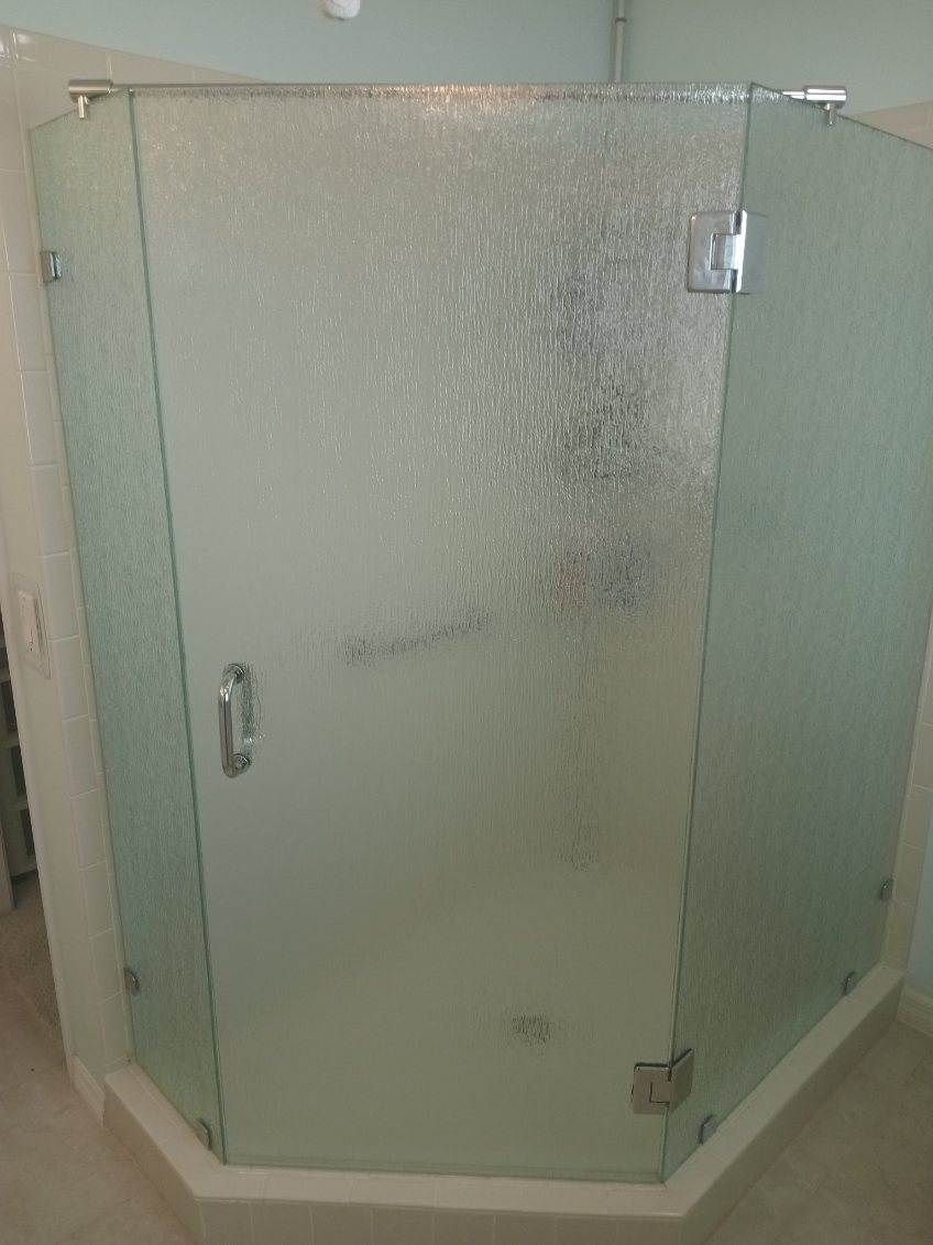 A bathroom glass shower door with fish and ocean life on it.