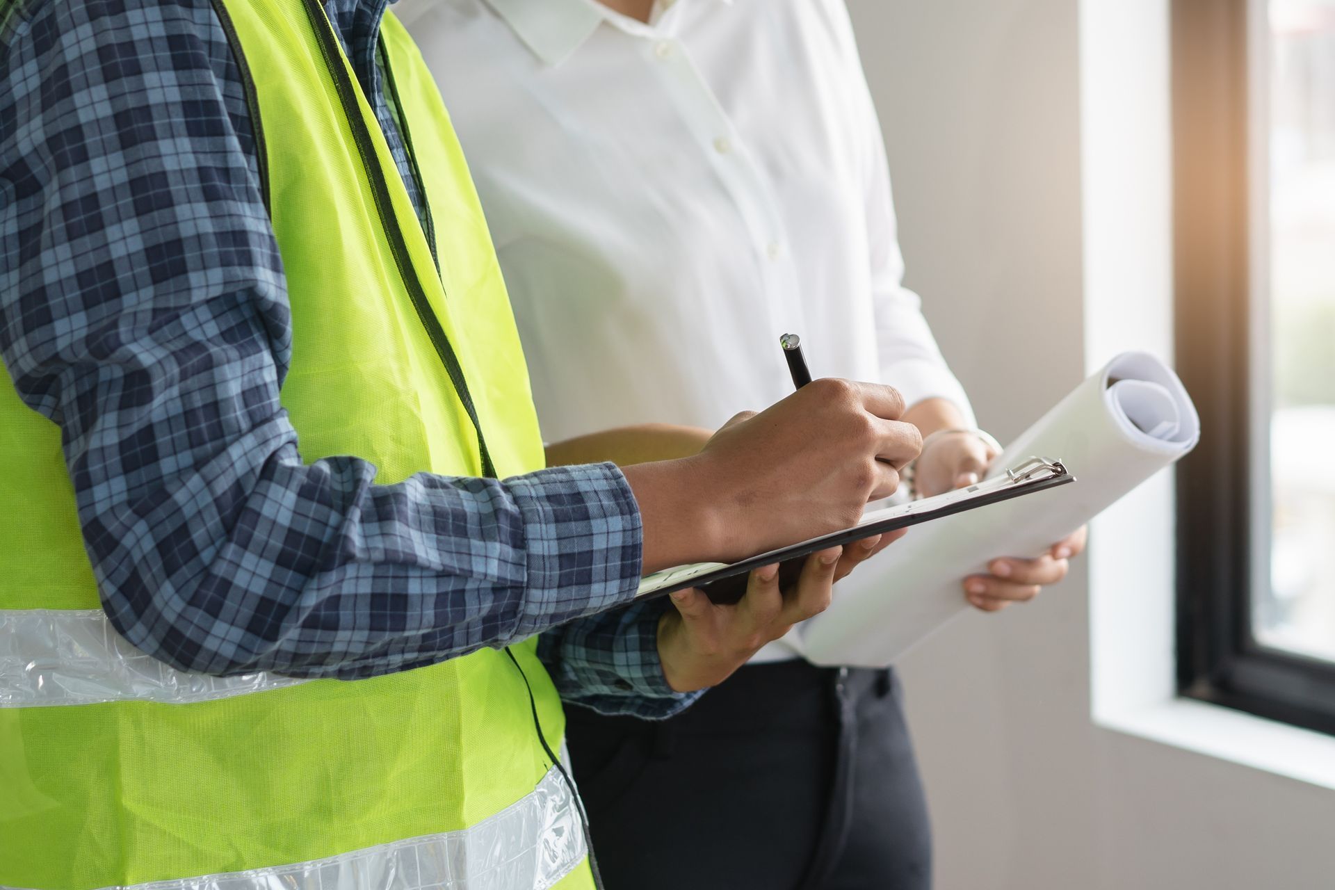 Un homme et une femme se tiennent l'un à côté de l'autre et regardent un presse-papiers.