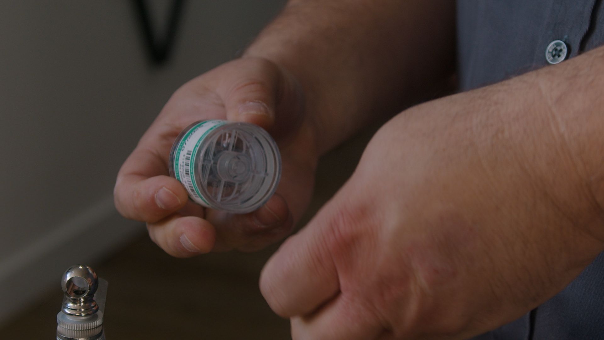 Un homme tient une bouteille de pilules dans ses mains.