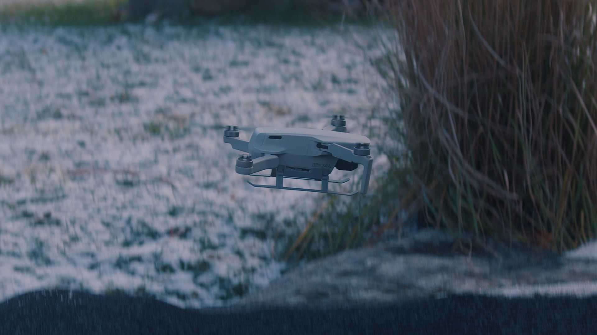 Un petit drone vole au-dessus d'un champ enneigé.