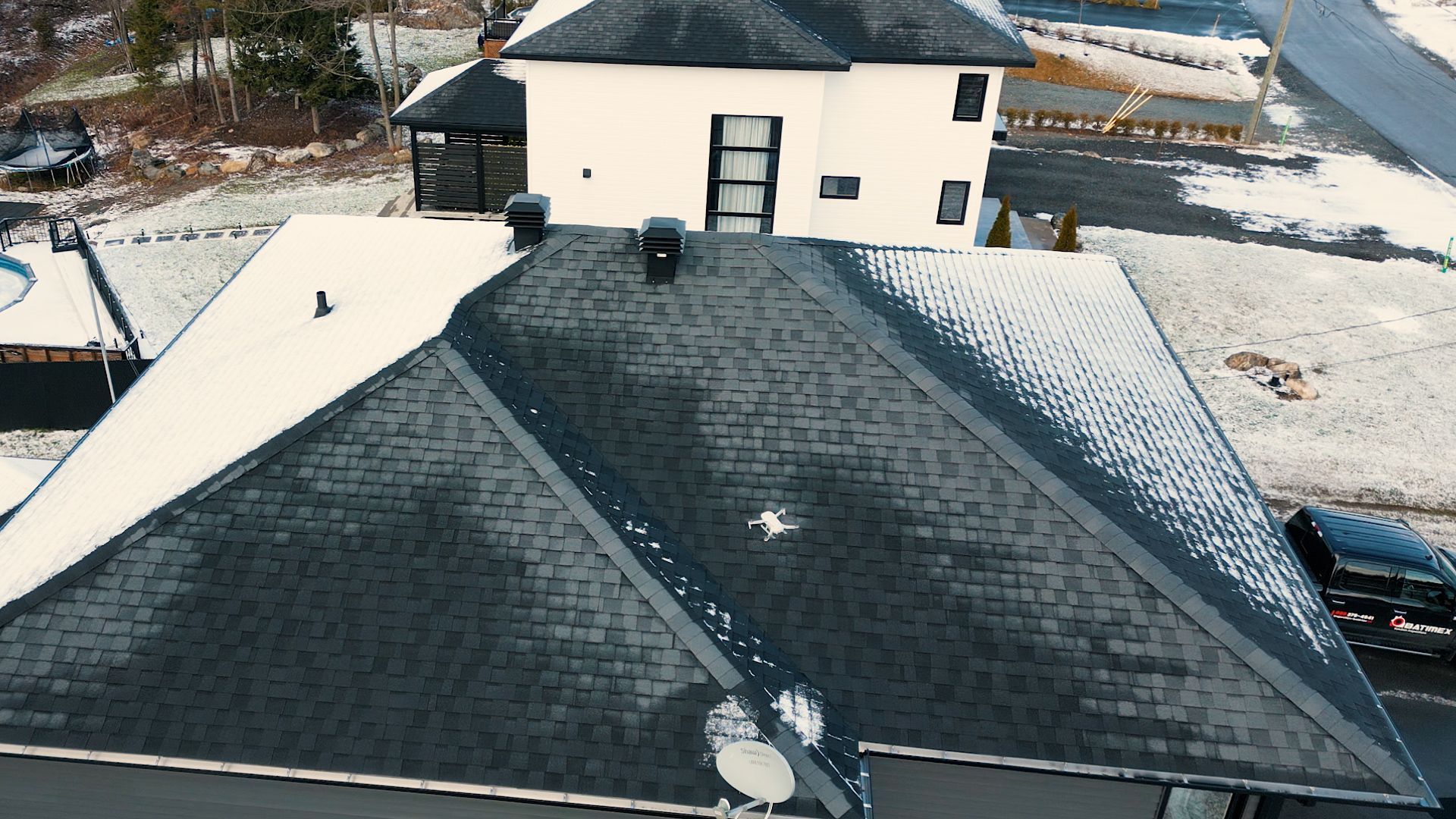 Une vue aérienne d'une maison avec une antenne parabolique sur le toit.