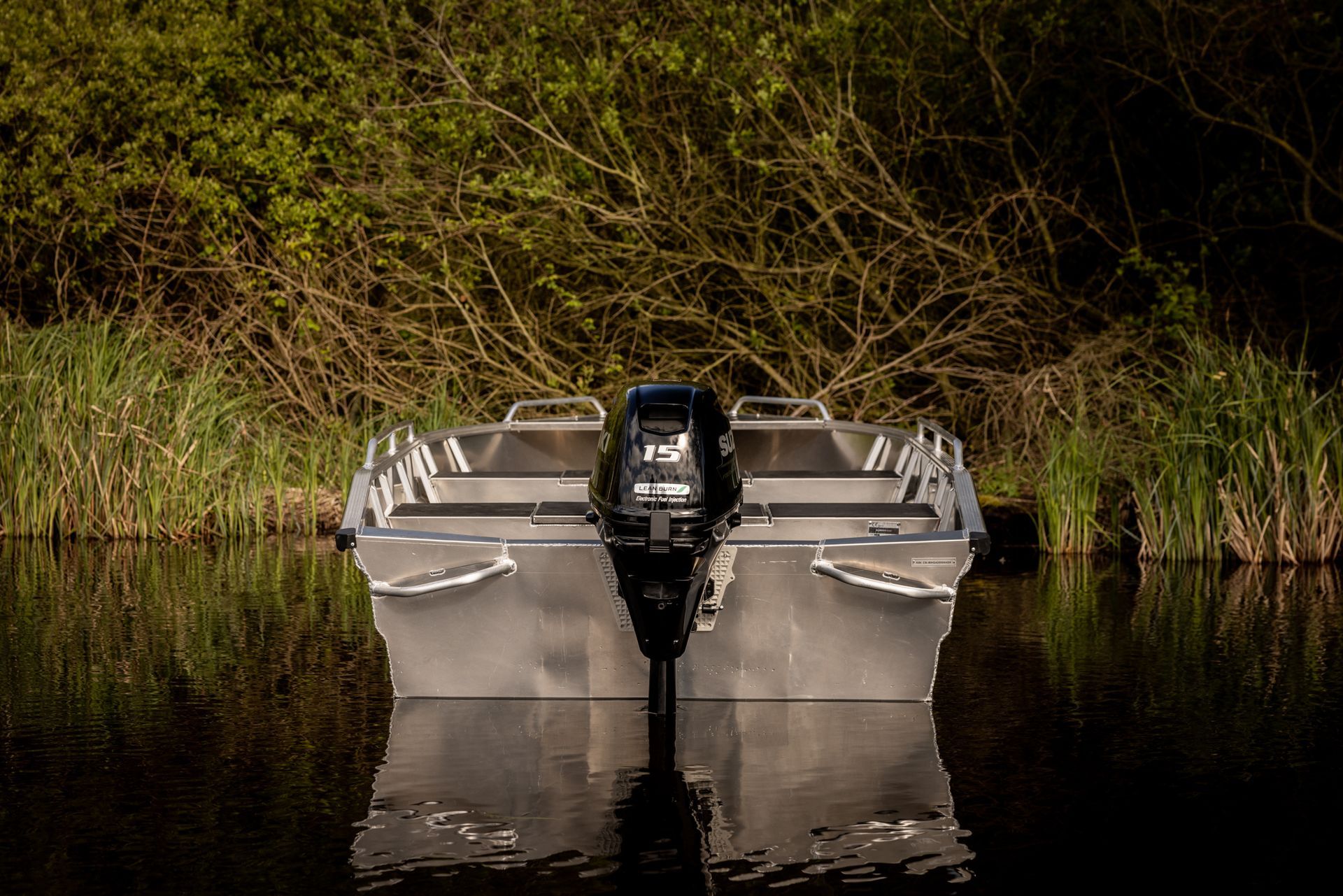 Een boot met een motor drijft op een watermassa.