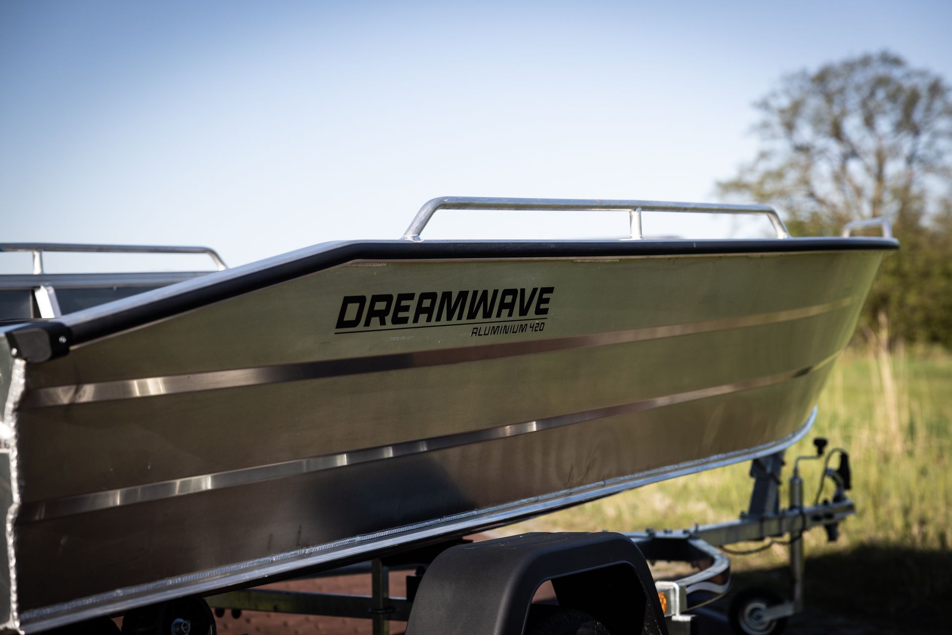 Een boot ligt op een trailer in een veld.