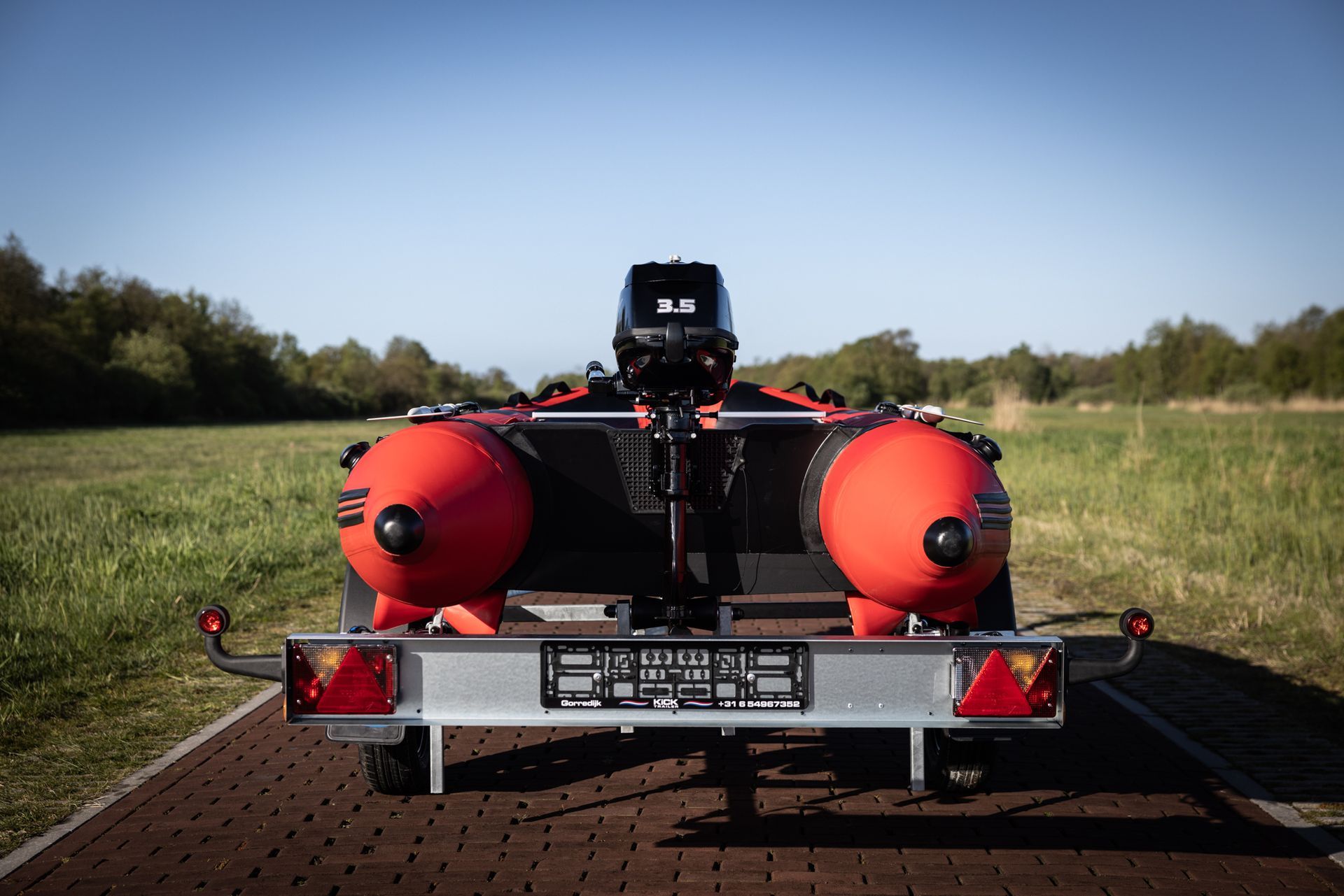 Een boot met daaraan een motor staat op een trailer.