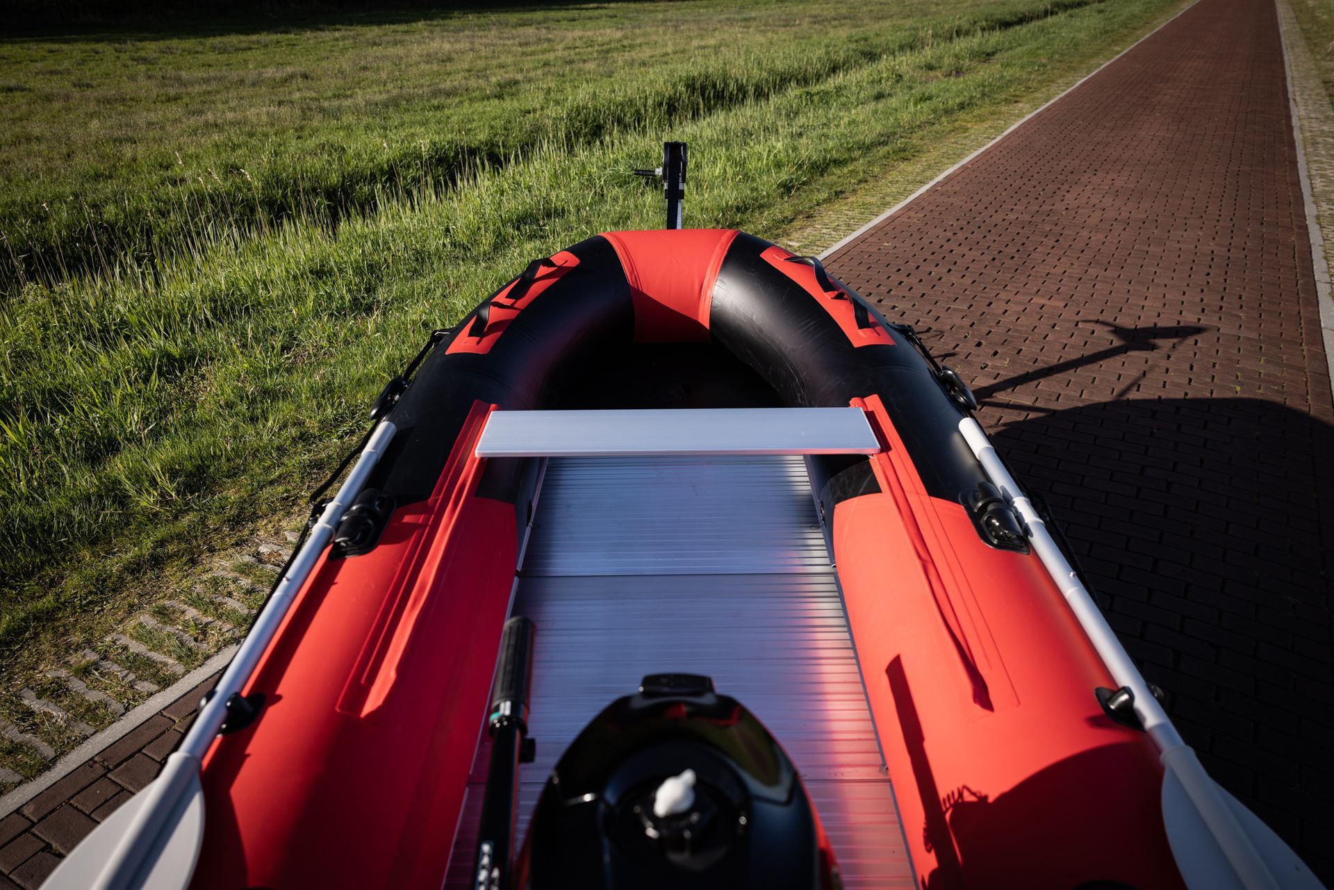 Een rood-zwarte boot staat geparkeerd aan de kant van een weg.