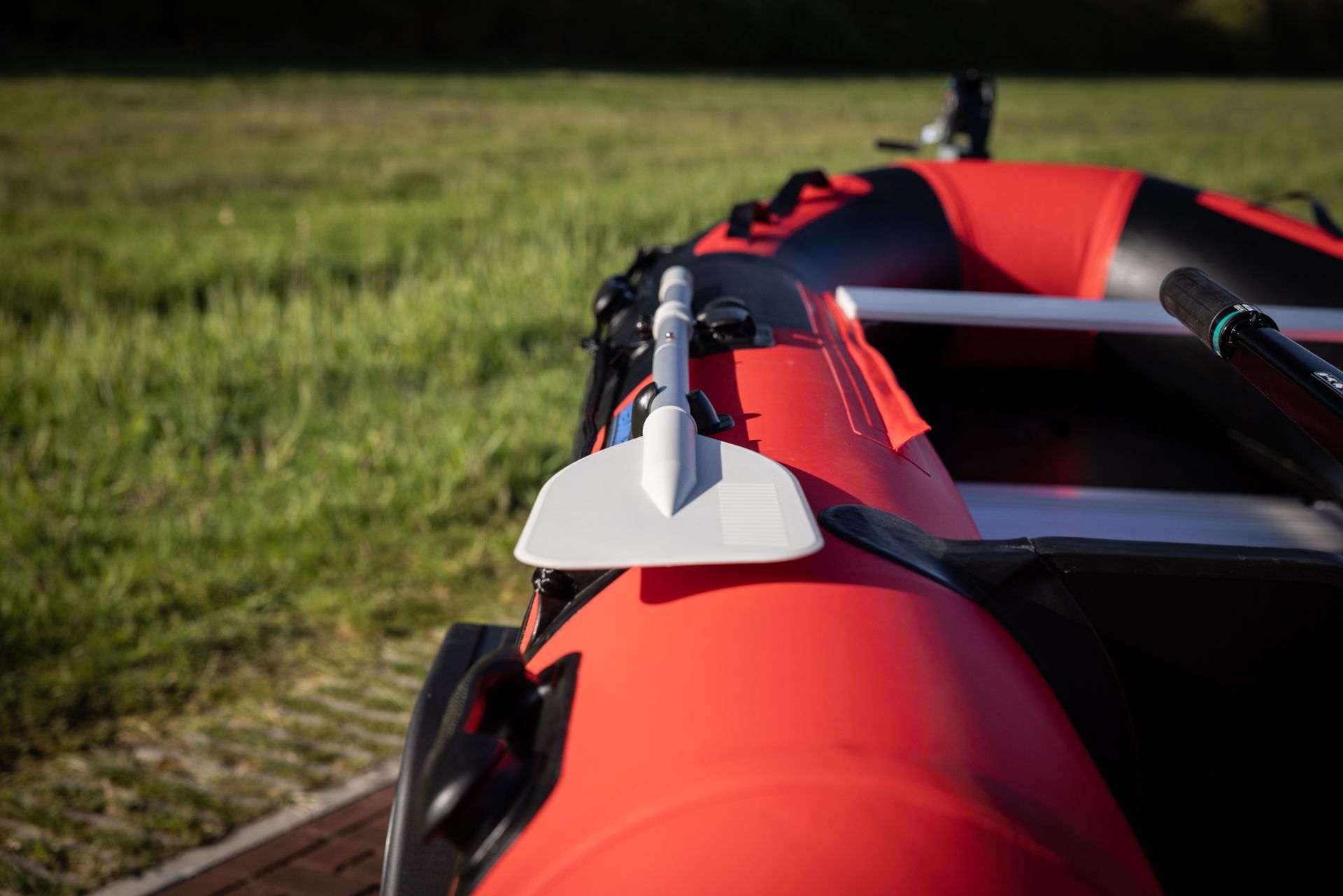 Een rood en zwart vlot met een witte peddel eraan.