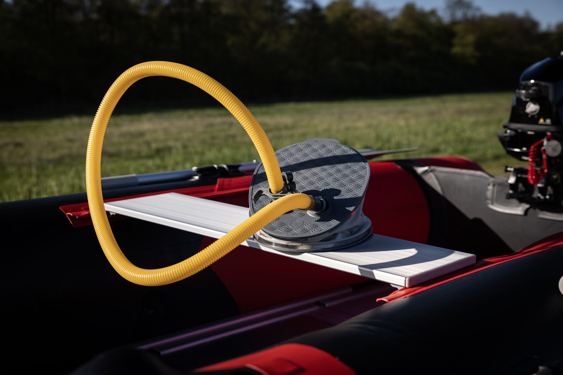 Aan de zijkant van een boot is een gele slang bevestigd.