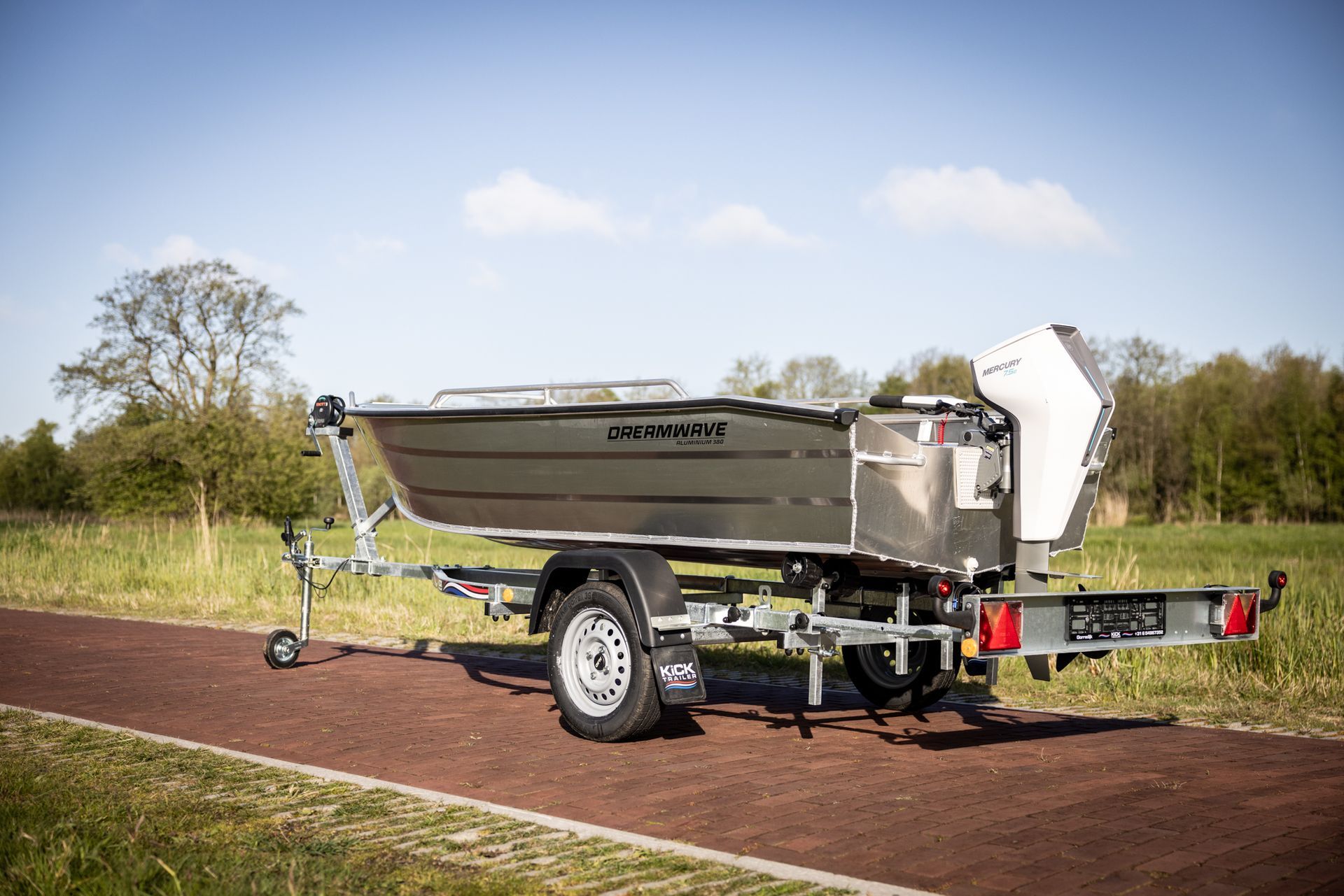 Een boot staat op een trailer die langs de kant van de weg geparkeerd staat.