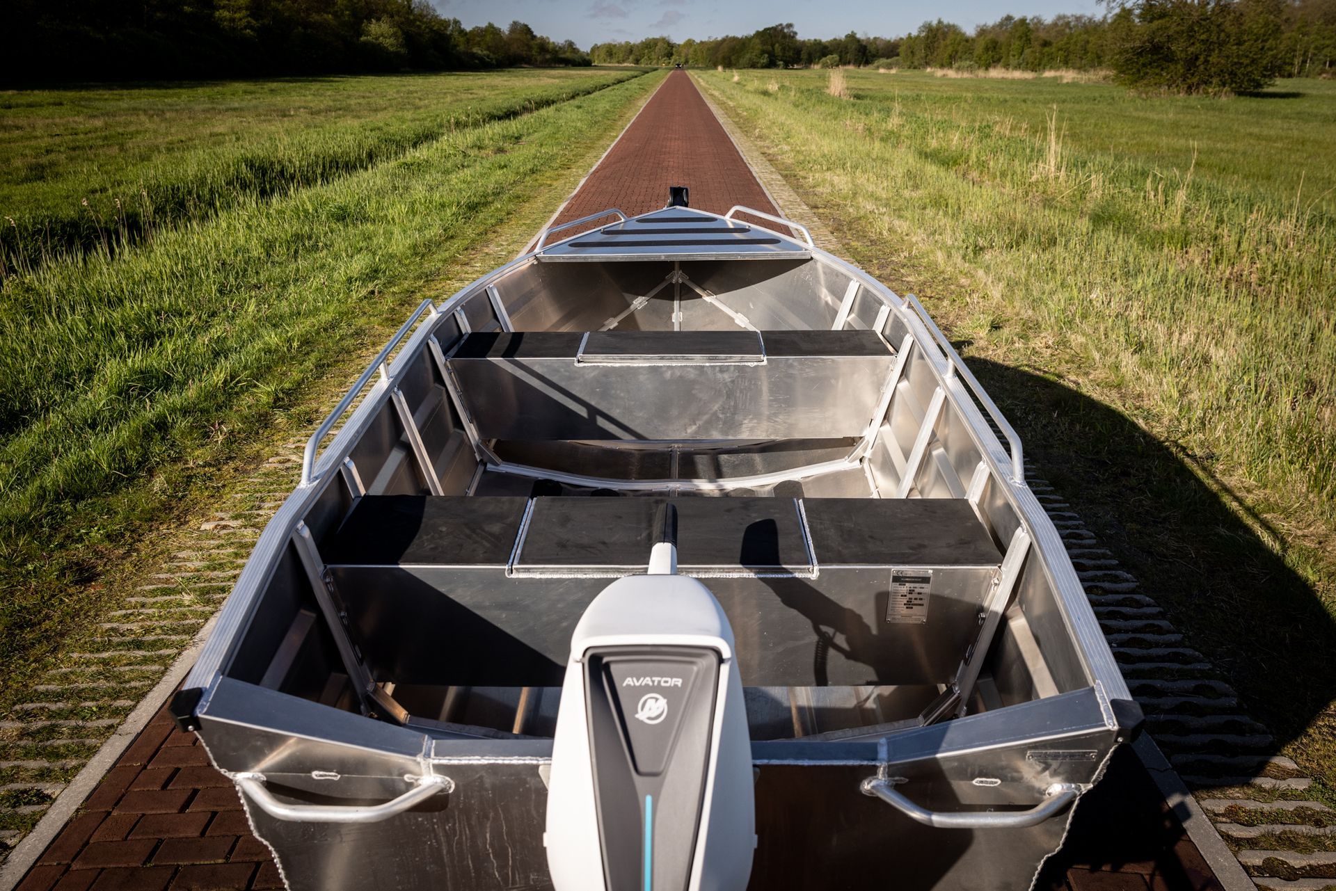Een boot staat geparkeerd op een stenen weg in een veld.
