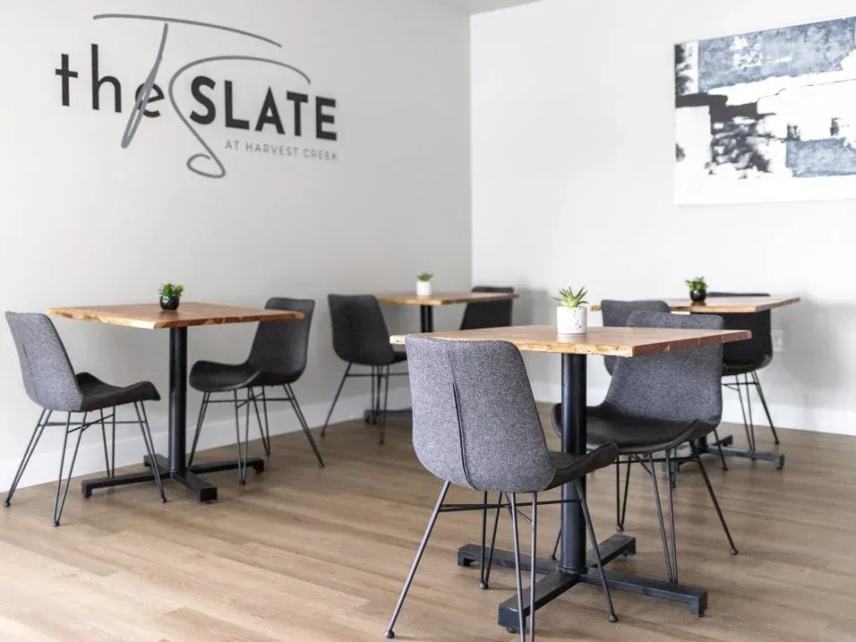 The Slate clubhouse with tables and chairs and a sign that says The Slate.