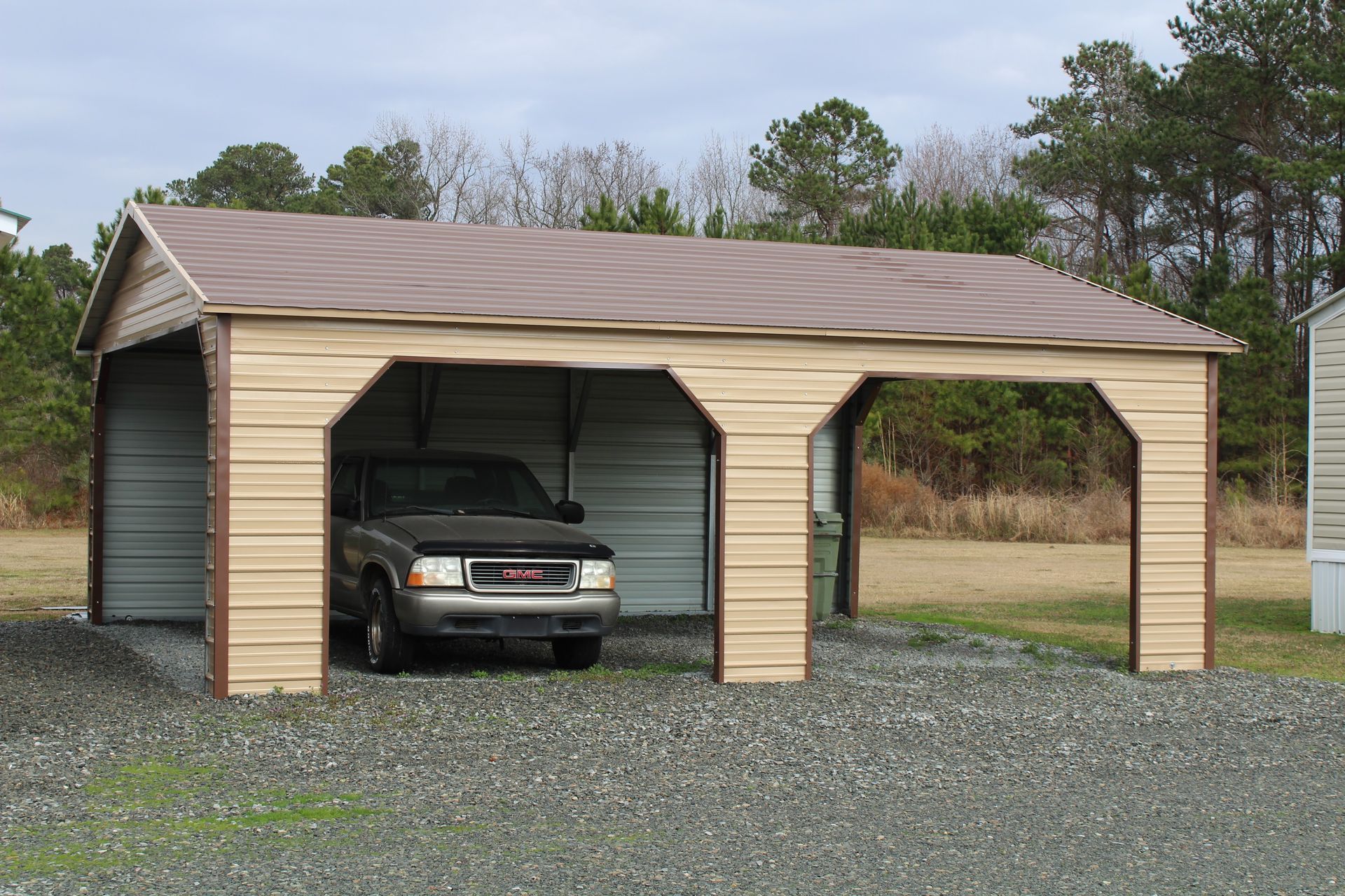 Man in blue overalls inspecting a large white garage door with a control panel.