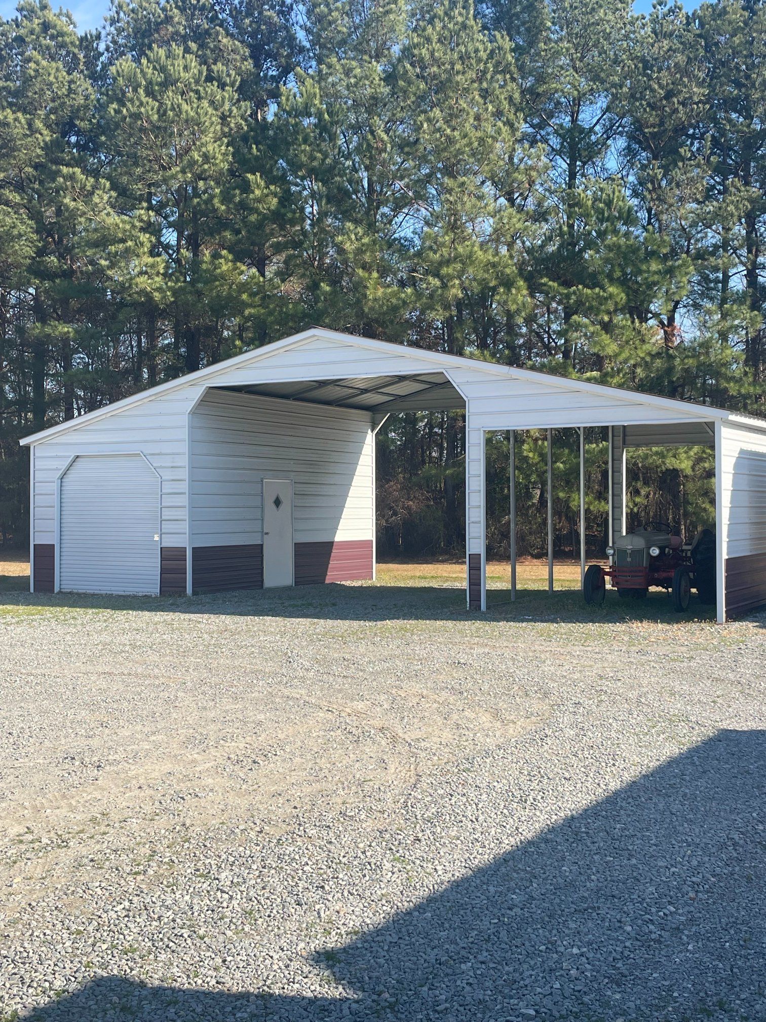 Tan storage shed with white trim, black hardware, and double doors outdoors.